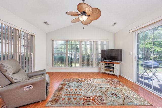 living area with a ceiling fan, vaulted ceiling, wood finished floors, and baseboards