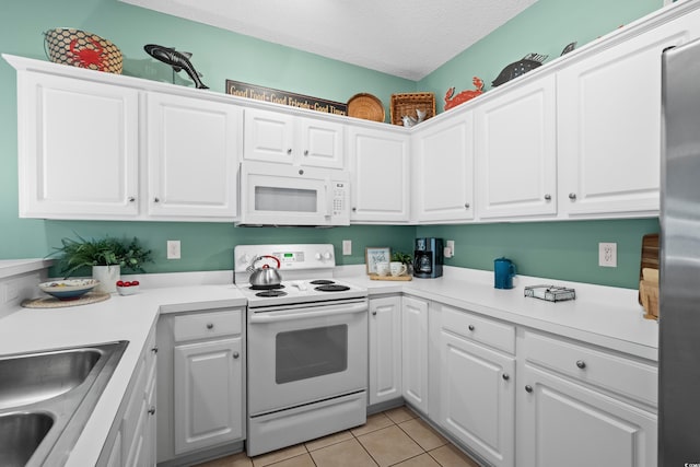 1058 Sea Mountain Hwy Unit 9-101, North Myrtle Beach, SC 29582 - kitchen featuring white appliances, white cabinets, light tile patterned floors, a textured ceiling, and light countertops