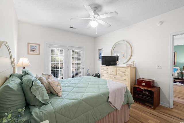 1058 Sea Mountain Hwy Unit 9-101, North Myrtle Beach, SC 29582 - bedroom with access to exterior, wood finished floors, a ceiling fan, and a textured ceiling