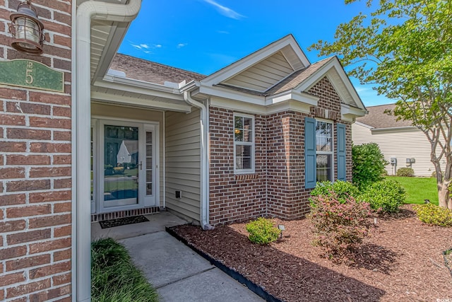 5 Coffee Mill Creek Ln, Carolina Shores, NC 28467 - doorway to property featuring brick siding and roof with shingles