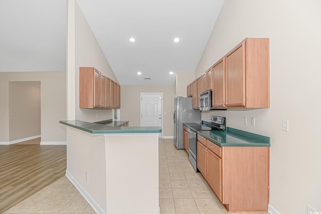 5 Coffee Mill Creek Ln, Carolina Shores, NC 28467 - kitchen with appliances with stainless steel finishes, lofted ceiling, dark countertops, a peninsula, and light tile patterned floors