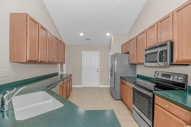 5 Coffee Mill Creek Ln, Carolina Shores, NC 28467 - kitchen featuring stainless steel appliances, a sink, dark countertops, light tile patterned floors, and vaulted ceiling