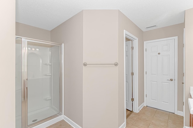 5 Coffee Mill Creek Ln, Carolina Shores, NC 28467 - bathroom with a stall shower, baseboards, tile patterned flooring, and a textured ceiling