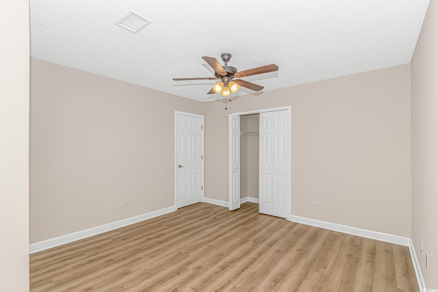 5 Coffee Mill Creek Ln, Carolina Shores, NC 28467 - unfurnished bedroom with light wood-type flooring, baseboards, a closet, ceiling fan, and a textured ceiling