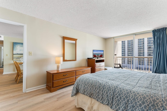 9820 Queensway Blvd Unit 804, Myrtle Beach, SC 29572 - bedroom featuring light wood-type flooring, a textured ceiling, baseboards, and floor to ceiling windows