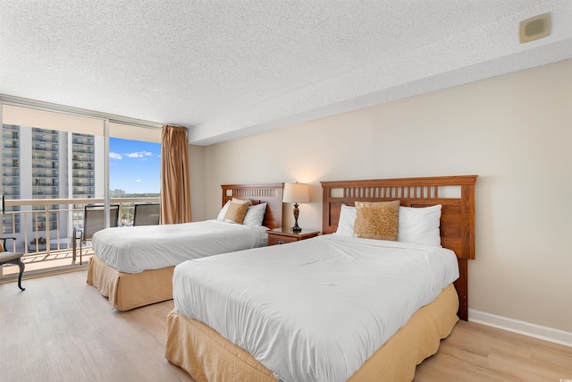 9820 Queensway Blvd Unit 804, Myrtle Beach, SC 29572 - bedroom with wood finished floors, a textured ceiling, expansive windows, access to exterior, and baseboards