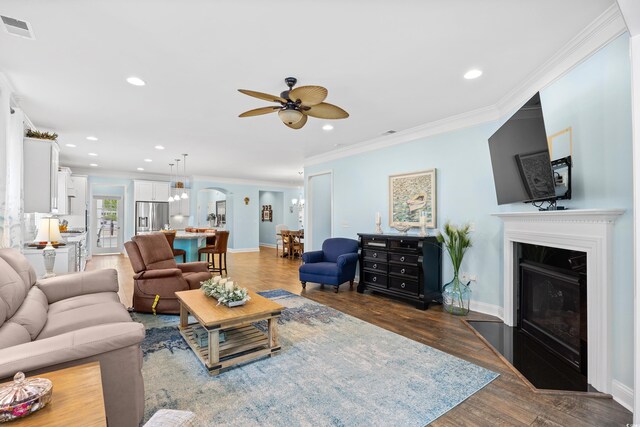 1290 Prescott Cir, Myrtle Beach, SC 29577 - living room featuring ceiling fan, a glass covered fireplace, crown molding, arched walkways, and wood finished floors
