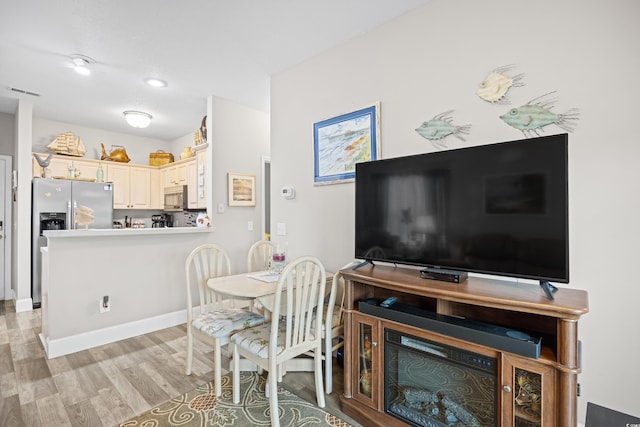 dining room featuring light wood-type flooring and baseboards