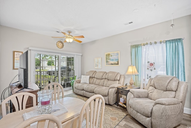 living room featuring a ceiling fan and light wood-style floors