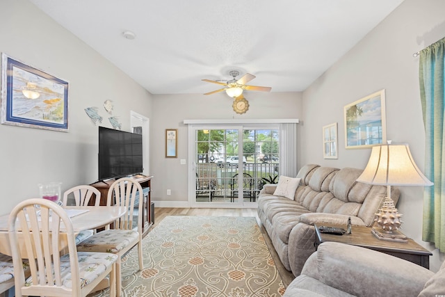 living room featuring a ceiling fan and light wood finished floors