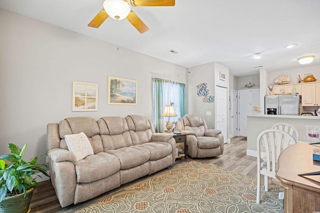 living area featuring light wood finished floors and ceiling fan