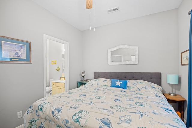 bedroom with connected bathroom and baseboards