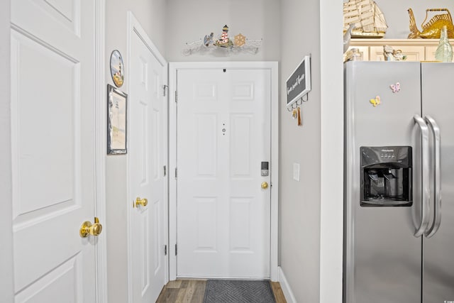 doorway to outside with wood finished floors and baseboards