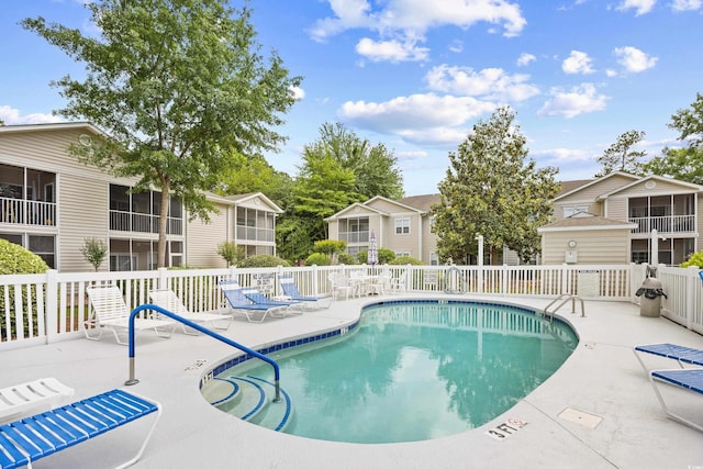 community pool featuring a patio area and fence