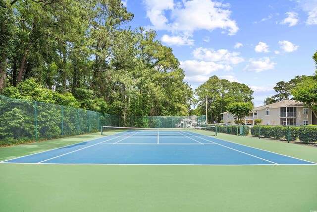 view of tennis court with community basketball court and fence