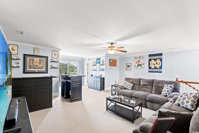living room featuring crown molding, a bar, a ceiling fan, baseboards, and light colored carpet