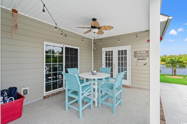 view of patio featuring french doors, a ceiling fan, fence, and outdoor dining area