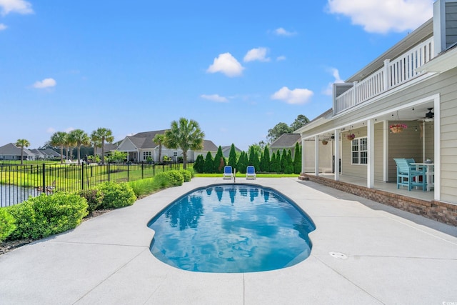 view of pool with a patio, fence, a residential view, and a ceiling fan