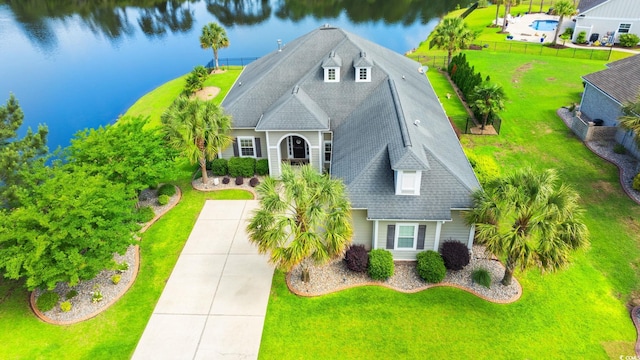 view of front of home with a water view, a shingled roof, and a front yard