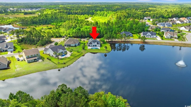aerial view of residential area featuring a heavily wooded area and a large body of water
