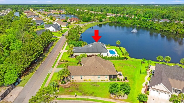 aerial perspective of suburban area featuring a nearby body of water and a forest
