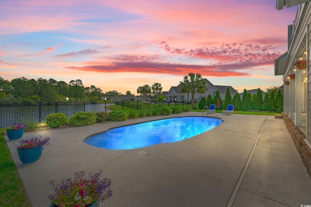 pool at dusk featuring a patio area and fence