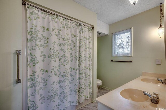 2010 Ye Olde Kings Hwy, North Myrtle Beach, SC 29582 - bathroom with double vanity, toilet, marble finish floors, a shower with curtain, and a textured ceiling