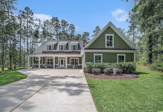 view of front facade with a porch, a front lawn, a standing seam roof, board and batten siding, and metal roof