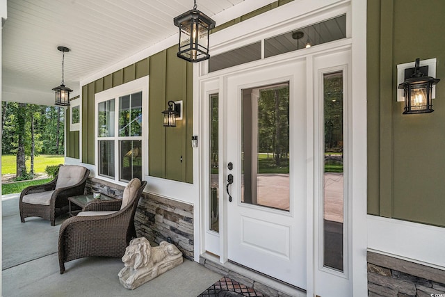 view of exterior entry featuring a porch and board and batten siding