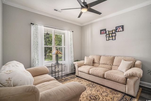 living area featuring wood finished floors, ornamental molding, ceiling fan, and baseboards