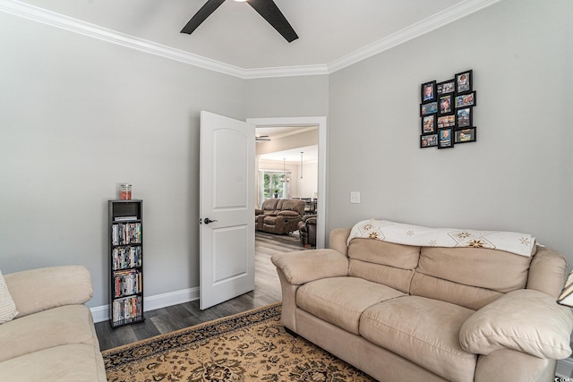 living area featuring a ceiling fan, wood finished floors, ornamental molding, and baseboards