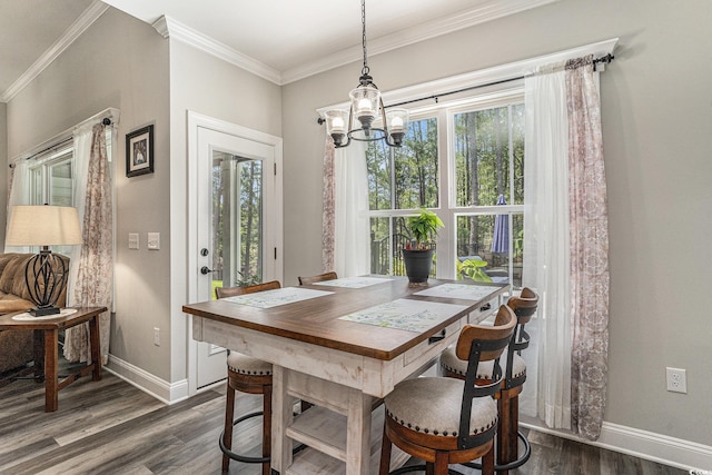 dining room featuring dark wood finished floors, a chandelier, baseboards, plenty of natural light, and crown molding