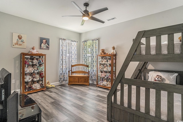 bedroom featuring wood finished floors, baseboards, and ceiling fan