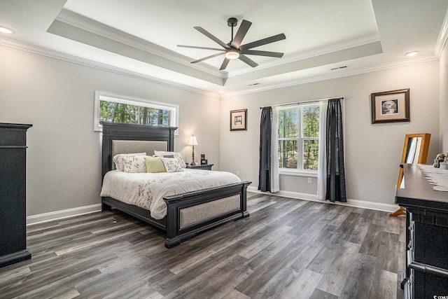 bedroom featuring a raised ceiling, dark wood-type flooring, crown molding, baseboards, and recessed lighting