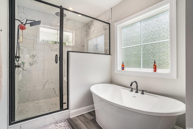 bathroom featuring a soaking tub, plenty of natural light, and a stall shower