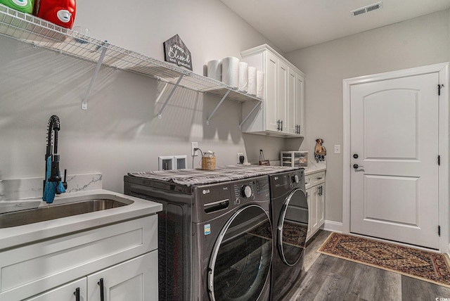washroom with washer and clothes dryer, dark wood-style floors, and cabinet space