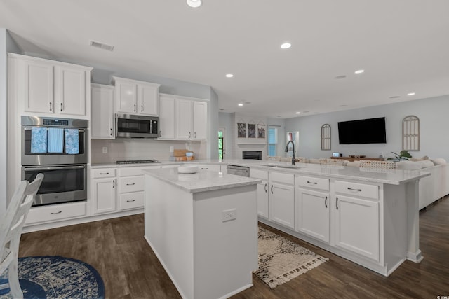 3620 Diamond Stars Way, Little River, SC 29566 - kitchen with appliances with stainless steel finishes, open floor plan, a center island, a peninsula, and white cabinetry