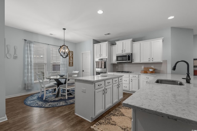3620 Diamond Stars Way, Little River, SC 29566 - kitchen with a sink, appliances with stainless steel finishes, dark wood finished floors, light stone counters, and backsplash