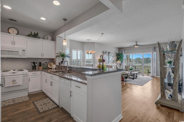 4450 Turtle Ln Unit 2-A, Little River, SC 29566 - kitchen with white appliances, a sink, a peninsula, a textured ceiling, and white cabinetry