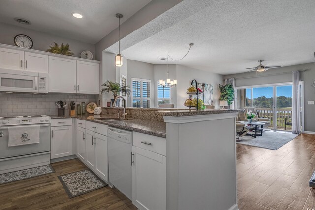 4450 Turtle Ln Unit 2-A, Little River, SC 29566 - kitchen with white appliances, a sink, a peninsula, white cabinetry, and a textured ceiling
