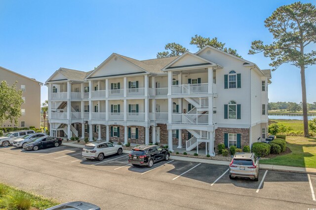 4450 Turtle Ln Unit 2-A, Little River, SC 29566 - view of building exterior with stairway, uncovered parking, and a water view