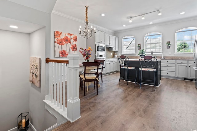 815 Murray Ave, Myrtle Beach, SC 29577 - kitchen featuring appliances with stainless steel finishes, crown molding, a center island, a kitchen bar, and light wood-type flooring
