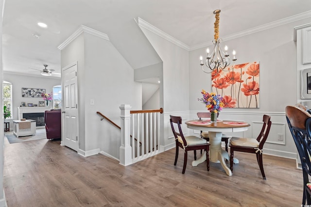 815 Murray Ave, Myrtle Beach, SC 29577 - dining area featuring wood finished floors, crown molding, a chandelier, ceiling fan, and a fireplace