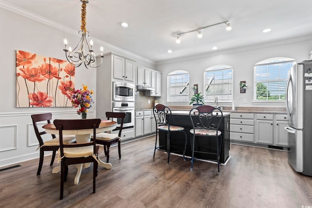 815 Murray Ave, Myrtle Beach, SC 29577 - kitchen with appliances with stainless steel finishes, crown molding, a kitchen island, a chandelier, and wood finished floors