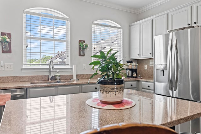 815 Murray Ave, Myrtle Beach, SC 29577 - kitchen with stainless steel appliances, a sink, crown molding, decorative backsplash, and light stone countertops