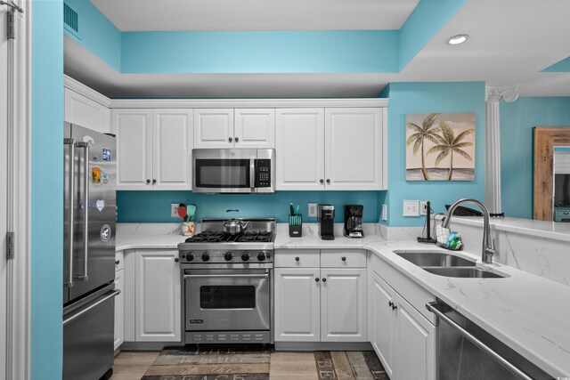 100 N Beach Blvd Unit 515, North Myrtle Beach, SC 29582 - kitchen featuring high quality appliances, white cabinets, recessed lighting, light wood-type flooring, and light stone counters
