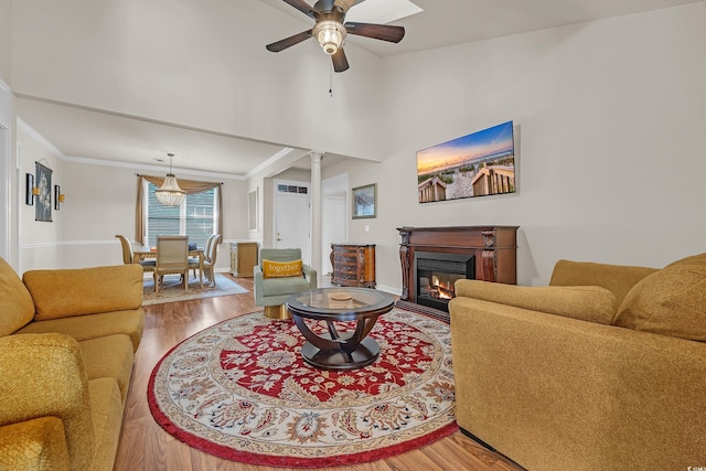 3071 Alice Ln, Little River, SC 29566 - living room featuring wood finished floors, a ceiling fan, a glass covered fireplace, baseboards, and decorative columns