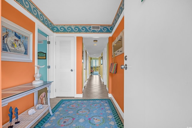 hallway with tile patterned floors and baseboards