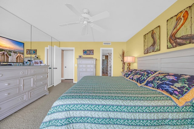 carpeted bedroom with ceiling fan and ensuite bath