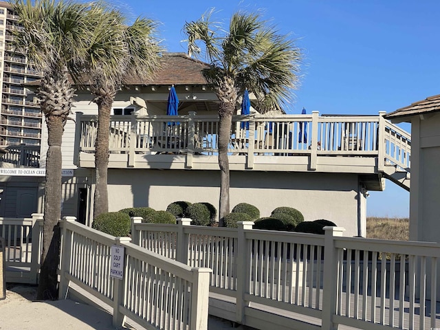 back of house featuring stucco siding and a deck